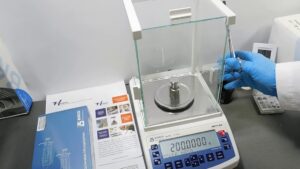 balanza analitica siendo calibrada con pesas de precision