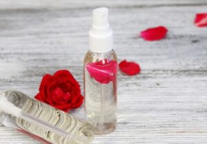 botella de suavizante y alcohol rodeados de flores