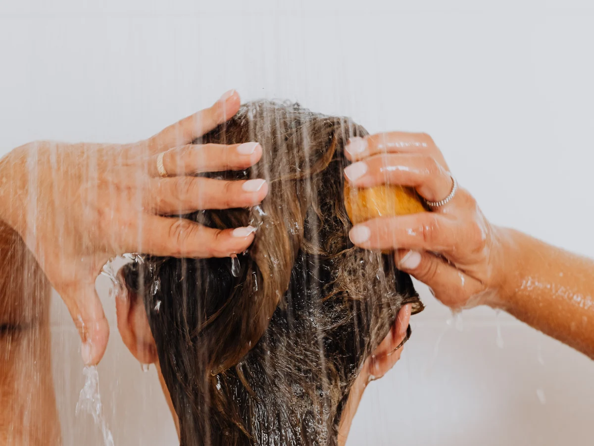 Mujer lavándose el cabello con agua
