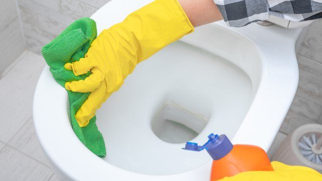 Persona limpiando suelo con agua fuerte