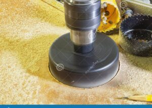 imagen de una mano utilizando una herramienta para hacer agujeros en madera