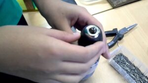 Guía paso a paso: Cómo poner broca en taladro Black & Decker 9 imagen manos colocando una broca en un taladro