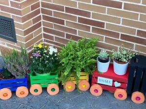 jardin con cajas de madera recicladas y coloridas