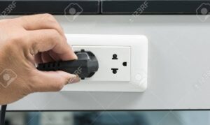 mano sosteniendo enchufe y desenchufando con seguridad