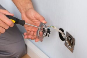manos conectando cables en enchufe e interruptor
