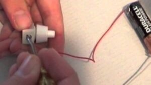 manos construyendo un circuito electrico casero