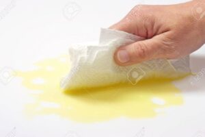 manos limpiando un derrame de aceite