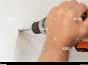 manos sosteniendo un taladro perforando plastico