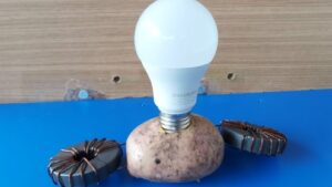 patata iluminada con cables y una bombilla