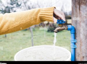 persona abriendo una llave de agua en casa