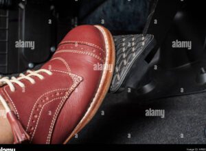 un pedal de freno siendo presionado por un pie