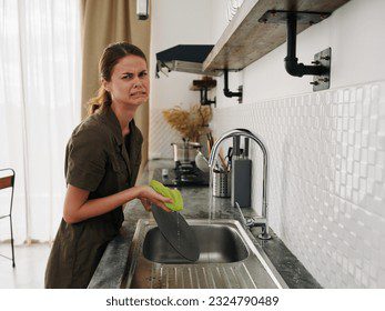 Qué significa lavar los platos en un sueño 4 Mujer lavando platos con expresión cansada